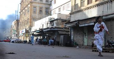 A young man, bleeding apparently due to gunshot wounds, runs for his life after "unknown assailants" opened fire at a rally in Karachi on May 22, 2012. Photo: Faysal Mujeeb/Whitestar
