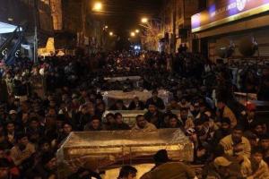 Haunting photo of grieving protestors sitting with coffins in the freezing cold in Quetta
