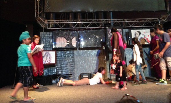 Audience members look at the artwork and cast before the show begins