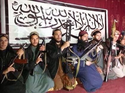 Not Muslim? Attackers of APS Peshawar photographed prior to their mission, in front of a banner inscribed with the first Kalima of Islam: "There is no god but Allah and Mohammad is His Prophet".