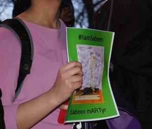 Vigil for Sabeen in Harvard Yard, April 28, 2015. Poster designed by Erum Sattar shows a painting by Frida Kahlo whom Sabeen loved. Photo: Ken Shulman